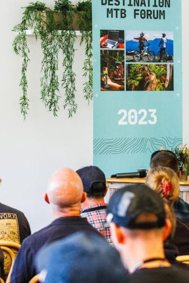 A man speaking to an audience at the destination mountain biking forum new zealand